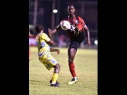 Waterhouse’s Donte Duncan (left) takes evasive action as Joel Cunningham of Arnett Gardens tries to control the ball during their Jamaica Premier League (JPL) encounter at Anthony Spaulding Sports Complex last night. Arnett won 1-0.