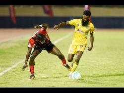 Rushawn Plummer (right) of Molynes United FC battles with Marlon Allen of Arnett Gardens FC during their Jamaica Premier League match at the Ashenheim Stadium last night. Arnett won 5-1.
