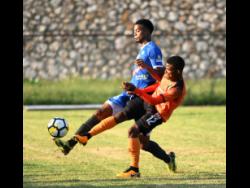 In this file photo, Portmore United’s Romaine Breakenridge (left) makes a clearance while under pressure from  Tivoli Garden’s Howard Morris during a Jamaica Premier League encounter at the Spanish Town Prison Oval in November 2018.