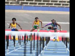 St Elizabeth Technical High’s Habiba Harris (left) on her way to victory  in the Under-20 girls’ 100 metres hurdles final at the Carifta Trials on Sunday at the National Stadium. Harris won in 13.35 seconds defeating Petersfield High’s Alexis James (right) who placed second in 13.38.