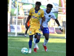 Nicholas Nelson (left) of Molynes United  dribbles away from Alvin Strachan of Vere United during their Jamaica Premier League encounter at the Anthony Spaulding Sports Complex yesterday. Molynes won 4-0.