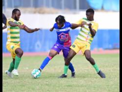 Portmore United’s Alex Marshall (centre) powers past Vere United’s Fitzroy Cummings (left) and Derwayne Dyer during their Jamaica Premier League match at  Ashenheim Stadium in February. Portmore won 2-0.
