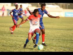Portmore’s Alex Marshall (left) dribbles away from Dunbeholden’s Ricardo Thomas during their Jamaica Premier League (JPL) match at the Ashenheim Stadium yesterday. Portmore won 3-1.