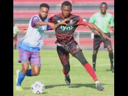 Portmore United’s Lamar Walker (left) tries to hold off a challenge from Arnett Gardens substitute Deshawn Plunkett during yesterday’s Lynk Cup round-of-16 encounter at the Anthony Spaulding Sports Complex, which Portmore won 3-2.
