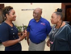Carlene Edwards (left), head of  promotions and sponsorship, JN Group, has the attention of Glen Mills (centre), meet director, Racers Grand Prix and Olivia Grange,  minister of culture, gender, entertainment and sports, during the launch of the 2023 Racers Grand Prix at The Jamaica Pegasus hotel in New Kingston yesterday.