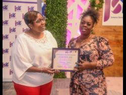 Stephanie Jackson (right), of August Town, St Andrew, receives a certificate from Winsome Hudson, trading manager at the Jamaica Social Investment Fund (JSIF), during last Thursday’s JSIF community awards at the AC Hotel by Marriot in Kingston. 