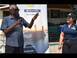 President of the St Catherine Cricket Association Milholland Barker (left) addresses the recent launch of the Jamaica Energy Partners (JEP) Cricket League at Chedwin Park while JEP’s Director of Corporate Affairs, Shared Values & Marketing, Melissa Newman, listens.