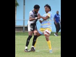 Waterhouse’s Shemar Boothe (right) and Cavalier’s Ronaldo Webster fight for possession during their Jamaica Premier League (JPL) football match yesterday at the Waterhouse Mini-Stadium. Waterhouse won 1-0.