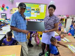 Clive ‘Busy’ Campbell (left) of Masters and Celebrities presents a computer to Arlene Leslie-Bernard, principal of the Maranatha Basic School, on behalf of the Bob Marley One Love football match and Bob Marley Foundation last Thursday at the school.