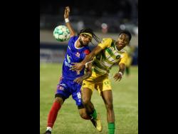 Vere United’s Dunsting Cohen (right) battles for the ball with Chevoy Watkin of Dunbeholden during their Jamaica Premier League (JPL) match at the Ashenheim Stadium last night. Dunbeholden won 3-1.