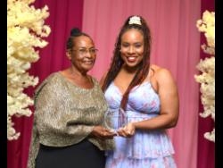 Dorrell Cousins (left) collects the Distinguished award in Agriculture for her granddaughter Toni-Ann Lalor from The Gleaner’s Debra Edwards.