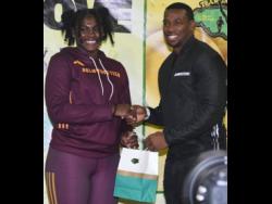 Cedricka Williams (left) receives her Team Jamaica Bickle (TBJ) award from Jamaica Olympic Games gold medallist Yohan Blake after she won the girls’ discus at the Penn Relays, Philadelphia, Pennsylvania, United States in a record.
