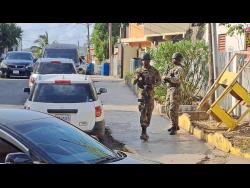 Soldiers patrol a section of Mount Salem, St James, following yesterday’s double murder in the community.