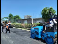 Workmen pave Garden Crescent in St James. The roadway is one of 12 roads currently being rehabilitated by the National Works Agency through the Government of Jamaica’s Islandwide Repair to Scoured and Damaged Roads Programme.