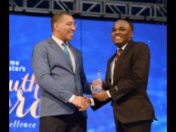 Prime Minister Andrew Holness (left) presents Abka Fitz-Henley with a Youth Award in 2018.