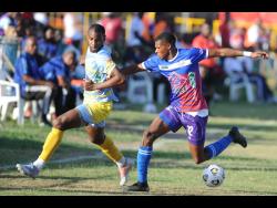 Gawain Austin (right) of Portmore United FC shields the ball from Gregory Messam of Waterhouse FC during a Jamaica Premier League match at the Ferdie Neita Park in Greater Portmore, St Catherine, on April 30, 2023.