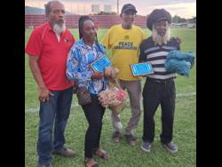 Peanut vendors Sonia Bloomfield (second left) and Levi Palmer (right) are joined by football administrator Carvel Stewart (left) and Clive ‘Busy’Campbell, organiser of the Bring Back the Love After Labour charity football event at the Anthony Spaulding Sports Complex on Tuesday, after being honoured for their service to football.