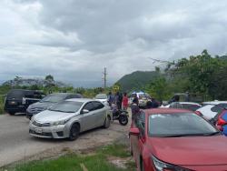 Police investigators search a section along the Eglinton main road in Spur Tree, Manchester, where the body of Reverend Orville Moore was found close to his wrecked vehicle. 
