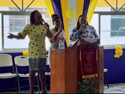 Sandra-Dean Moore (right), the widow of the late deputy commissioner of corrections Reverend Orville Moore, sings with the praise team at Santa Cruz Holiness Christian Church in St Elizabeth during service yesterday.