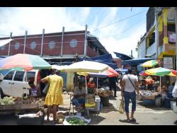 Vendors seek sales for their wares in Linstead, St Catherine, after several stalls went up in flames on June 1.
