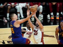 Denver Nuggets centre Nikola Jokic (left) drives to the basket over Miami Heat forward Kevin Love (right) during the second half of Game 3 of the NBA Finals last night. Nuggets won 109-94.
