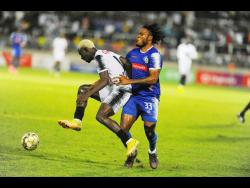 Cavalier’s Colin Anderson (left) tries to evade the challenge of Mount Pleasant’s Shaquille Dyer during the Jamaica Premier League (JPL) final at Sabina Park on Sunday. Anderson scored, but Cavalier lost the match 2-1.