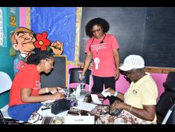 Medical Director of the HOPE Mission 360 Dr Alicia Shelly (left) and volunteer registered nurse, Comeile Johnson (centre), attend to 80-year-old Vera Beecher during a free medical clinic at Golden Grove Primary in St Ann, on Sunday.