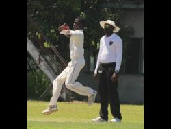 Zachary Taylor of Campion College is about to send down a delivery against St Catherine High during the final of the ISSA under-14 competition at Chedwin Park on Thursday. Looking on is umpire Ryan Forrest.