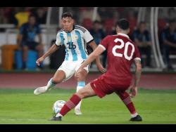 Argentina’s Nahuel Molina (left) battles for the ball against Indonesia’s Shayne Pattinama during their friendly football match at Gelora Bung Karno Main Stadium in Jakarta, Indonesia, yesterday. Argentina won 2-0.