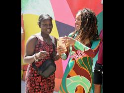 American actress Kerry Washington (right) interacts with Ayesha Laing, one of her many fans in Jamaica, during the Kingston Creative Art Walk monthly festival themed ‘We Locking Down Church Street” in Kingston on Sunday. Washington is soaking up the sun in Jamaica.