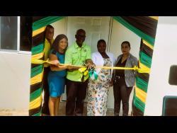 Minister of Local Government and Community Development, Desmond McKenzie (centre), cuts the ribbon to officially hand over a new indigent housing unit to beneficiary Shawya Farquharson (second right) in Brompton, St Elizabeth, on Thursday. Sharing the occasion are (from left) Mayor of Black River, Councillor Derrick Sangster; Councillor of the Brompton Division, Whitney Smith-Currie; and Corporate Secretary for the Board of Supervision, Treka Lewis.

 