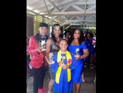 Young Zamani Smith is surrounded by his father, Royston Smith, stepmother Sophia Fraser-Smith (centre) and mother Samara Letts at his graduation from Bellas Gate Primary School in St Catherine on Wednesday.