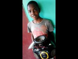 Tyreek Hendricks shows off the regular table radio that he converted into a Bluetooth device.