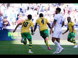Jamaica’s Amari’i Bell (second left) celebrates with teammates Bobby Reid (left) and Leon Bailey (right) after scoring against Guatemala during their Concacaf Gold Cup quarter-final match  at TQL Stadium in Cincinnati, Ohio, yesterday. Jamaica won 1-0 and advanced to the semi-finals.  