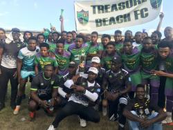 The coaching staff and fans from Treasure Bach FC pose with the JFF National Tier II trophy following a 2-1 win over Lime Hall Academy FC at Foga Road High School in Clarendon yesterday.