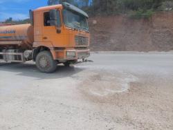 A truck sprinkles water along the roadway in Seven Miles, Bull Bay, St Andrew.