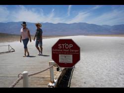 A sign warns visitors of extreme heat danger at Badwater Basin in Death Valley National Park yesterday.
