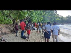 Haitians exiting the Boston Beach in Portland, under the supervision of the police on July 10. They were later taken to hospital for screening.