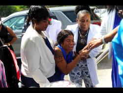 Relatives and friends try to console Sudiene Mason, the mother of  eight-year-old Danielle Rowe, at the funeral service at the Portmore Seventh-day Adventist Church in St Catherine yesterday.