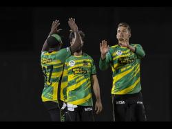 Jamaica Tallawahs’ spinner Chris Green (right) is congratulated by teammates after picking up a wicket during their opening CPL encounter against the St Lucia Kings last night in St Lucia.