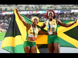 Jamaica’s Shelly-Ann Fraser-Pryce (left) and Shericka Jackson celebrate finishing second and third in the women’s 100 metres final at the World Championships in Budapest, Hungary, yesterday. The race was won by the United States of America’s Sha’Carri Richardson.