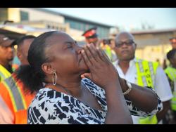 Julian Mendez, stepmother of 17-year-old Alecia King, who was set ablaze on Thursday in an attack, weeps as the teen boards a flight at the Norman Manley International Airport in Kingston yesterday. She is heading to Texas for life-saving treatment.