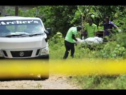 Funeral home workers remove the bodies of 43-year-old Omar Wellington, his pregnant wife, 35-year-old Sharon Francis-Wellington, and their 16-year-old son, Orlando Wellington, who was a student at Innswood High School. The family was murdered yesterday morning at their home in Waterloo, St Catherine.
