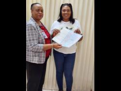 Diandra ‘Chichibella’ Francis (right) receives a copy of her birth certificate from administrative assistant of the Registrar General’s Department Patricia Miller-Ward in Montego Bay, St James, yesterday.