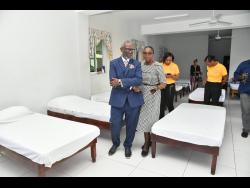 Minister of Local Government and Community Development, Desmond McKenzie (left), and Inspector of Poor, Kingston and St Andrew, Mavis Farquharson, tour a dormitory at the Desmond McKenzie Transitional Centre for the Homeless on King Street in Kingston.