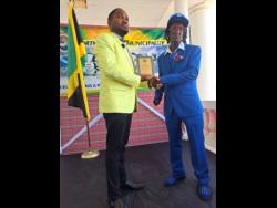 Peter Mathis receives his award from Rovel Morris, CEO of the Portmore City Municipality, during yesterday’s civic award ceremony in Portmore, St Catherine.