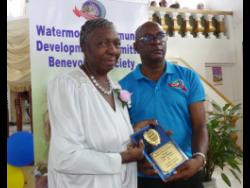 President of the Watermount Community Development Committee Benevolent Society in St Catherine, Carlos McLeod (right), presents Elaine Hyman with a plaque in recognition of her decades of services to the community. The occasion was a function held recently at the Pedro Church of Christ to recognise nine community members for outstanding voluntary service.