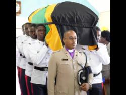 Police personnel carry the coffin bearing the remains of Constable Justin Martin who was murdered by gunmen in Clarendon in August.