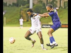 Arnett Gardens’ Kimani Arbourine (left) shields the ball from Molynes United’s Taraj Andrews during last night’s Wray and Nephew-sponsored Jamaica Premier League match at the Stadium East. Arnett won 4-0.