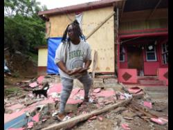 Marjorie Sterling clears rubble from a wall of one of her bedrooms in Cottage Hill, St Andrew